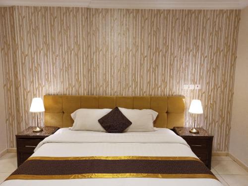 una camera da letto con un grande letto con due comodini di شقة الفخامة a Gedda
