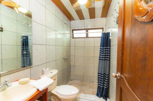 ein Badezimmer mit einem WC, einem Waschbecken und einem Spiegel in der Unterkunft Casa Almendro Playa Panamá in Panamá