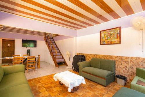a living room with green couches and a table at Casa Almendro Playa Panamá in Panamá