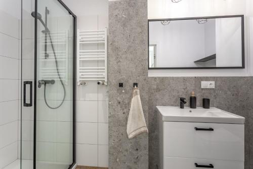 a bathroom with a shower and a sink and a mirror at Apartament "Przy Szlaku" - Ostoja Parku in Szklarska Poręba