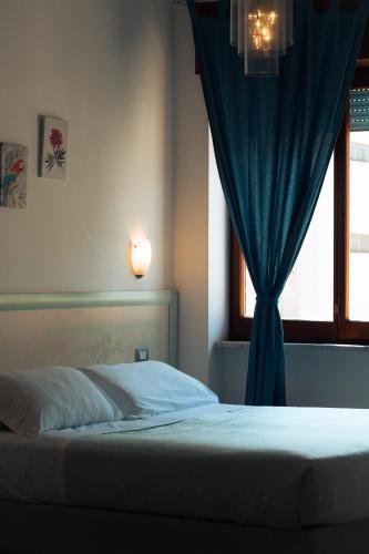 a bedroom with a bed with a blue curtain at Le Case della Costa - Apartment Positano in Maiori