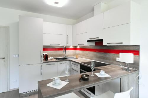 uma cozinha com armários brancos e um balcão de madeira em Golf Apartment 114 em Beroun