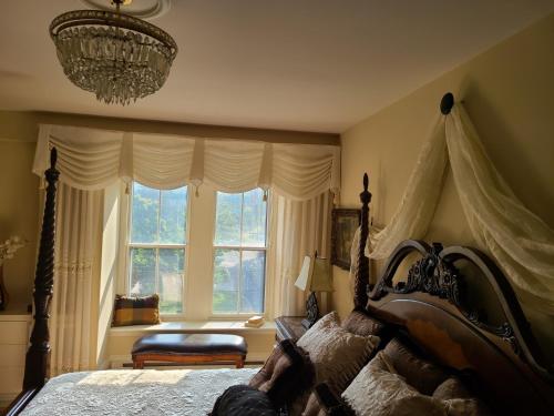 a bedroom with a bed with a chandelier and a window at Iconic Luxurious Downtown Building History Galore in Halifax