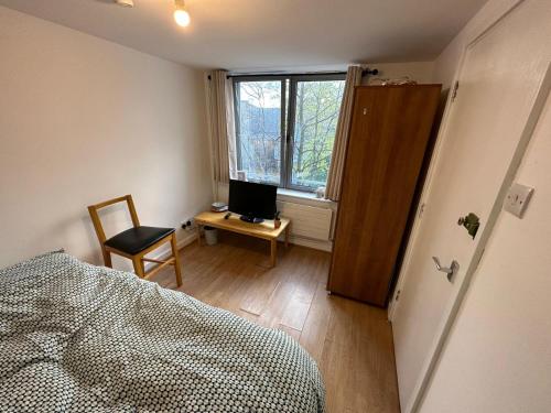 1 dormitorio con 1 cama y escritorio con ordenador en Newbury, en Londres