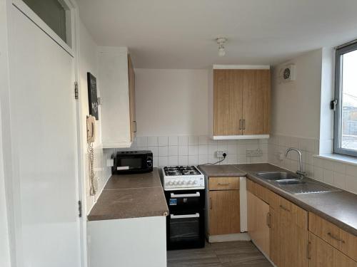 a small kitchen with a stove and a sink at Newbury in London