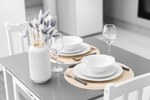 a dining room table with plates and wine glasses at New Luxury Apartment - Cradley Heath - 2MH - Parking - Netflix - Top Rated in Birmingham
