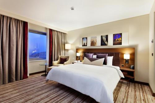 a hotel room with a large bed and a large window at Hilton Garden Inn Mardin in Mardin