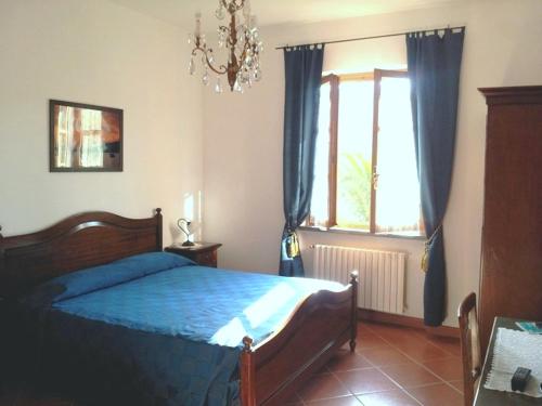 una camera con un letto blu e una finestra di Agriturismo Villa Bardi struttura con camere vista mare a Riva Trigoso