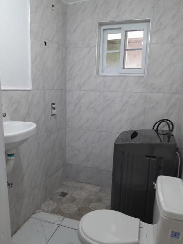 a bathroom with a toilet and a sink at Cozy 2 bed in Ocho Rios in Ocho Rios