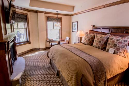 1 dormitorio con 1 cama y 1 mesa en una habitación en Aspen Mountain Residences, Luxury 2 BR Residence 15,1 Block from Ski Lifts en Aspen