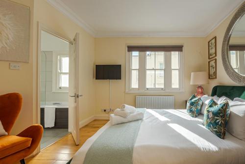 ein Schlafzimmer mit einem großen weißen Bett und einem Spiegel in der Unterkunft Beautiful House in Knightsbridge in London