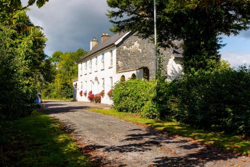 a white house with a road in front of it at Willsgrove House in Athy