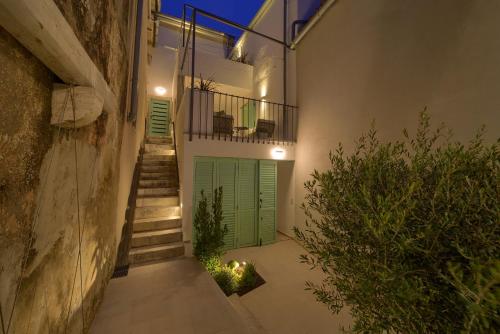 a hallway with a green garage door and stairs at Bastinica Platinum Ap 4 * * * * * in Krk