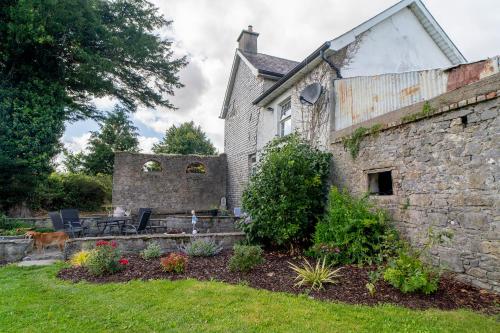 an old stone house with a garden in the yard at Willsgrove House in Athy