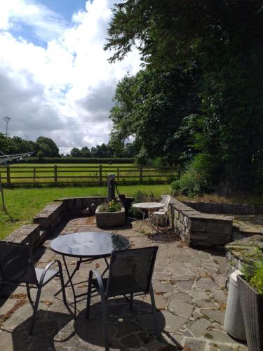 a patio with a table and chairs and a fence at Willsgrove House in Athy