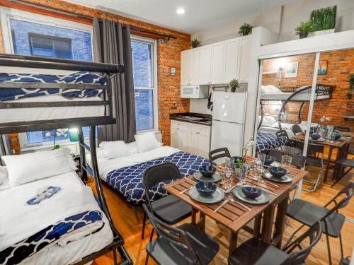 Empire Broadway Retreats في نيويورك: غرفة مع طاولة طعام وسرير بطابقين