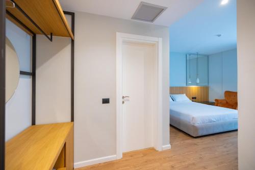 a bedroom with a bed and a room with a door at DUKA Hotel in Vlorë