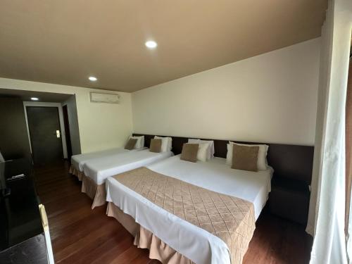 a hotel room with two beds and a window at Hotel Fazenda Monte Castelo in Gravatá