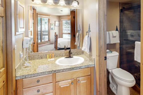 a bathroom with a sink and a toilet and a mirror at Lodge at Steamboat B205 in Steamboat Springs