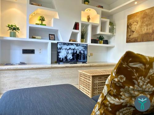 sala de estar con TV y sofá en Dos Torres Ático Dúplex - Céntrico con Vistas a la Ciudad, en Zaragoza