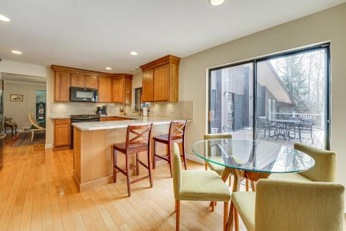 a kitchen and dining room with a glass table at Bloomfield Retreat with Pool 6 Mi to Riverside Park in Bloomfield Hills