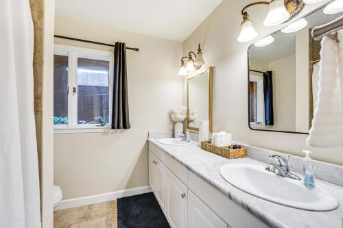 a bathroom with two sinks and a mirror at Bloomfield Retreat with Indoor Pool and Tennis Court! in Bloomfield Hills