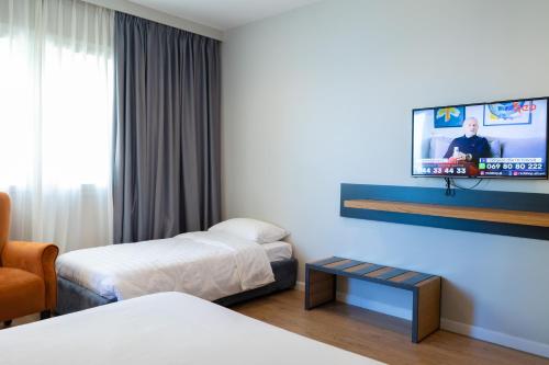 a hotel room with two beds and a flat screen tv at DUKA Hotel in Vlorë