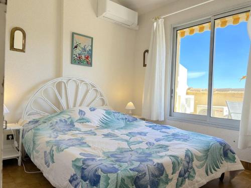 une chambre avec un lit et une grande fenêtre dans l'établissement Appartement 3 pièces 6 pers avec terrasse, clim, piscine privée, parking - FR-1-251-81, au Lavandou