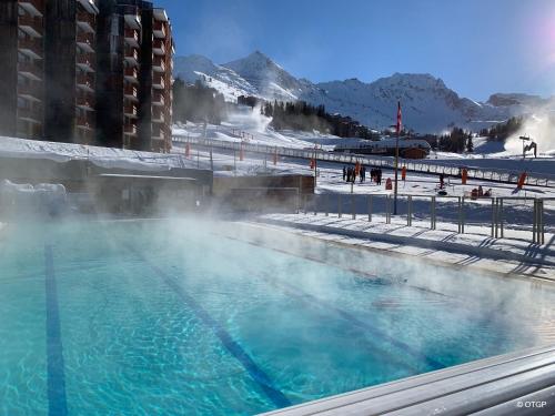 a hot tub with steam coming out of it at travelski home classic - Résidence Bellecôte in La Plagne