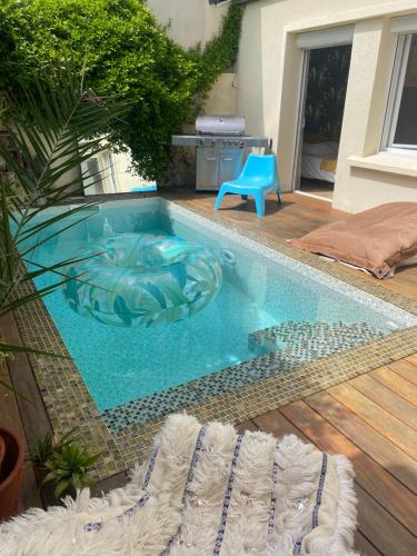 een zwembad met een blauwe stoel in een tuin bij Jasmin House 2 in Cenon