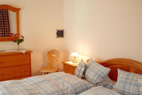 a bedroom with a bed and a dresser with a lamp at FeWo Talblick - Urlaub wo der Schwarzwald am schönsten ist in Baiersbronn