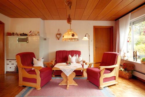 ein Wohnzimmer mit Stühlen, einem Tisch und einem Tisch in der Unterkunft FeWo Talblick - Urlaub wo der Schwarzwald am schönsten ist in Baiersbronn