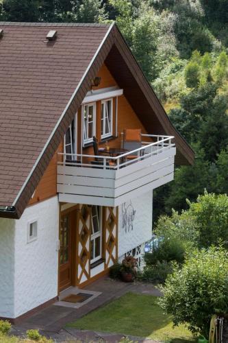 ein Haus mit einer umlaufenden Veranda und einem Balkon in der Unterkunft FeWo Talblick - Urlaub wo der Schwarzwald am schönsten ist in Baiersbronn