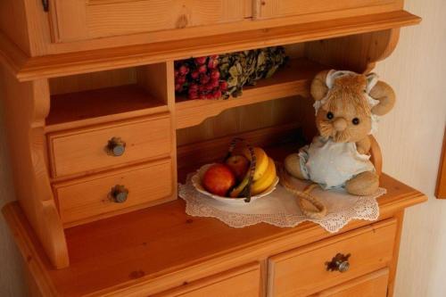 a stuffed animal sitting in a cabinet with a bowl of fruit at FeWo Talblick - Urlaub wo der Schwarzwald am schönsten ist in Baiersbronn