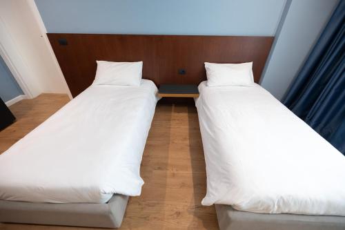 two beds sitting next to each other in a room at DUKA Hotel in Vlorë