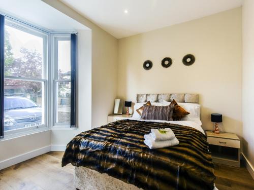 Ealing Queen of the Suburbs One Bedroom Apartment Pass the Keys في لندن: غرفة نوم بسرير كبير ونافذة