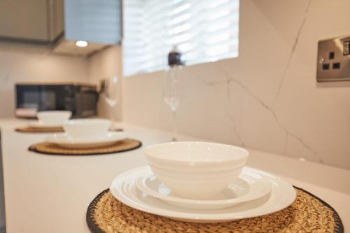 a white bowl on a plate on a kitchen counter at Unique 5 Bedroom Fully upgraded with Parking x4 in Earlham