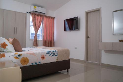 sypialnia z łóżkiem, telewizorem i oknem w obiekcie APARTAMENTO - AIRE ACONDICIONADO w mieście Valledupar