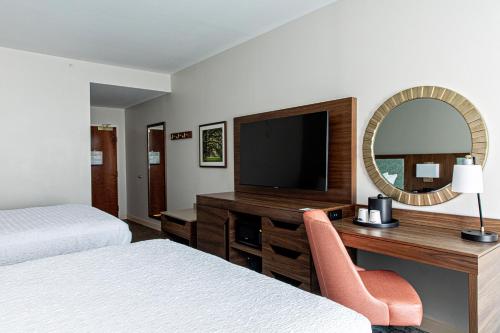 a hotel room with a desk and a television at Hampton Inn & Suites Charleston-West Ashley in Charleston
