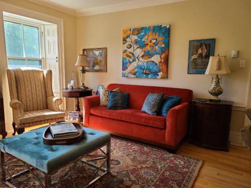 a living room with a red couch and a chair at Iconic Luxurious Downtown Building History Galore in Halifax