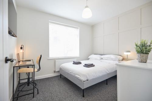 biała sypialnia z łóżkiem i biurkiem w obiekcie Unique 5 Bedroom Fully upgraded with Parking x4 w mieście Earlham