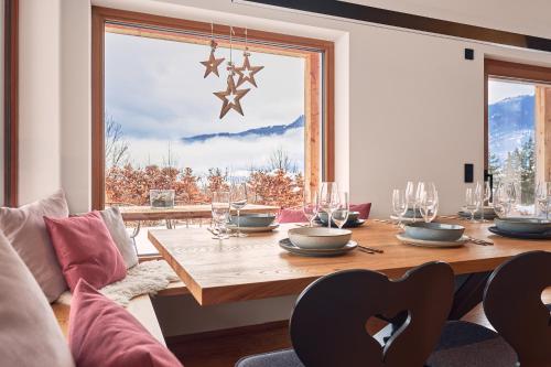 a dining room with a table and a large window at designchalets auf 685 in Reit im Winkl