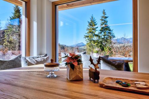 a dining table with a large window with a view at designchalets auf 685 in Reit im Winkl