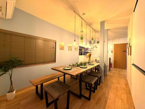 a dining room with a long table and chairs at 【海水浴場まで3分！】リノベーションされた古民家を貸切！ANGO KUJUKURI3 in Kujukuri