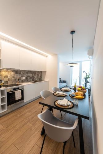a kitchen with a table and chairs in a room at Brum Design Apartments I in Ponta Delgada