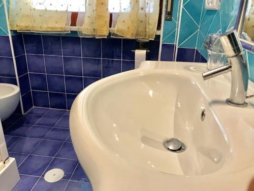 a white sink in a blue tiled bathroom at Le Case della Costa - Appartamento Capri in Maiori