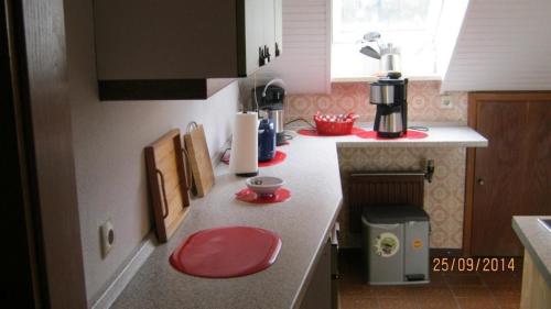 una cocina con encimera con taburetes rojos. en Schöne Ferienwohnung am Wald gelegen mit großem Sonnenbalkon, 