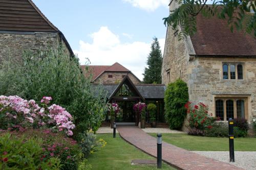 an old stone house with a garden and flowers at voco Oxford Thames by IHG in Oxford