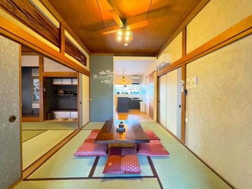 a living room with a table on the floor at 【海水浴場まで3分！】リノベーションされた古民家を貸切！ANGO KUJUKURI3 in Kujukuri