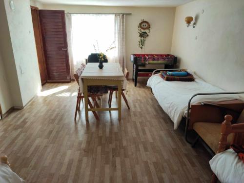 a room with two beds and a table and a desk at Guest House Bovada / Къща за гости Бовада 
